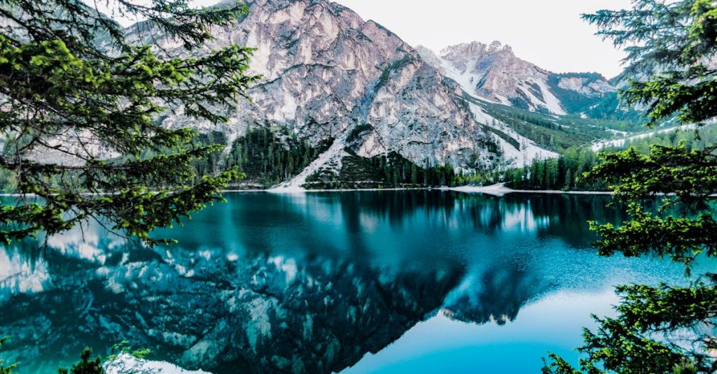 pexels-photo-443446-443446 Serene mountain lake with stunning reflections in Braies, Italy, surrounded by trees.